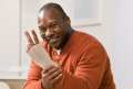 Injured man with wrist splint gesturing the peace symbol